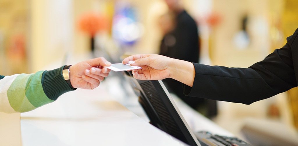 two women exchanging a credit card