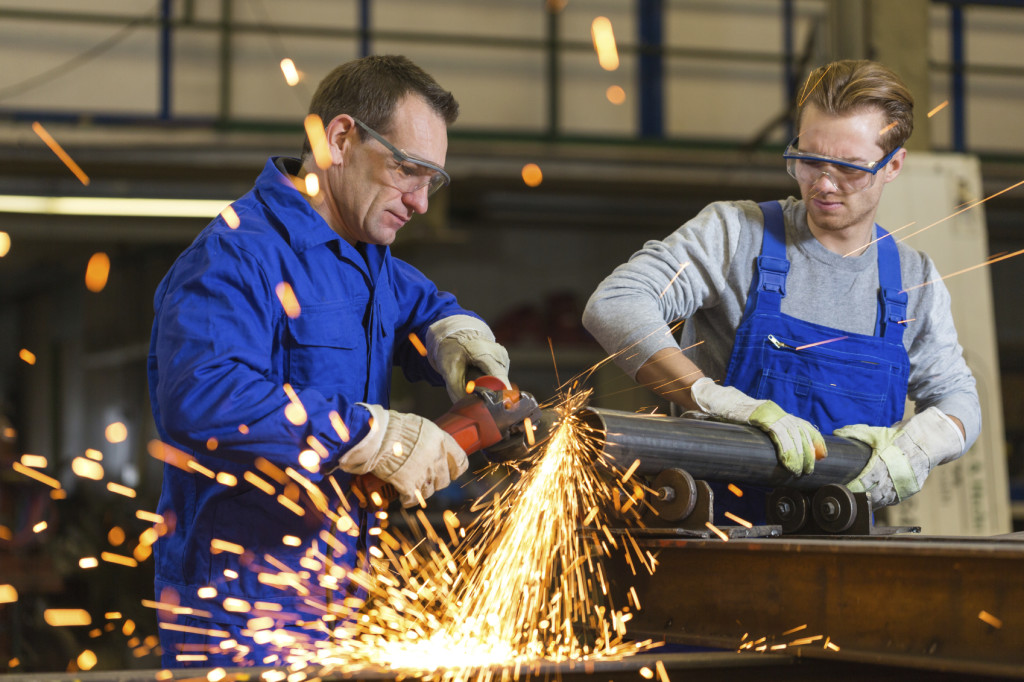 Two workers working with angle grinder Aberdeen Strategy & Research